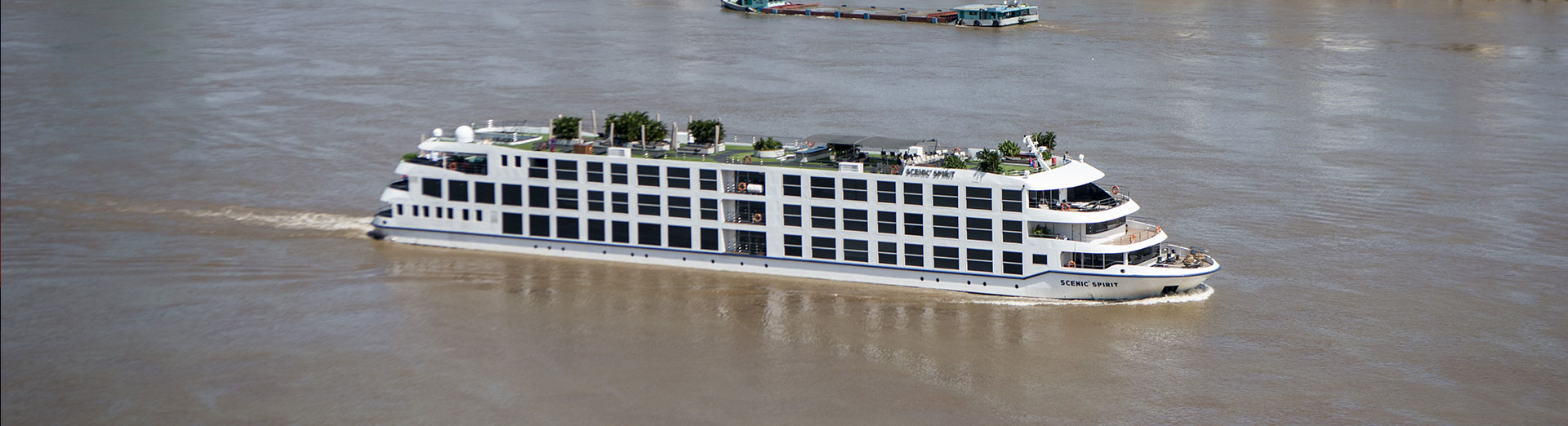 Modern white river cruise ship sailing on the brown waters of the Mekong