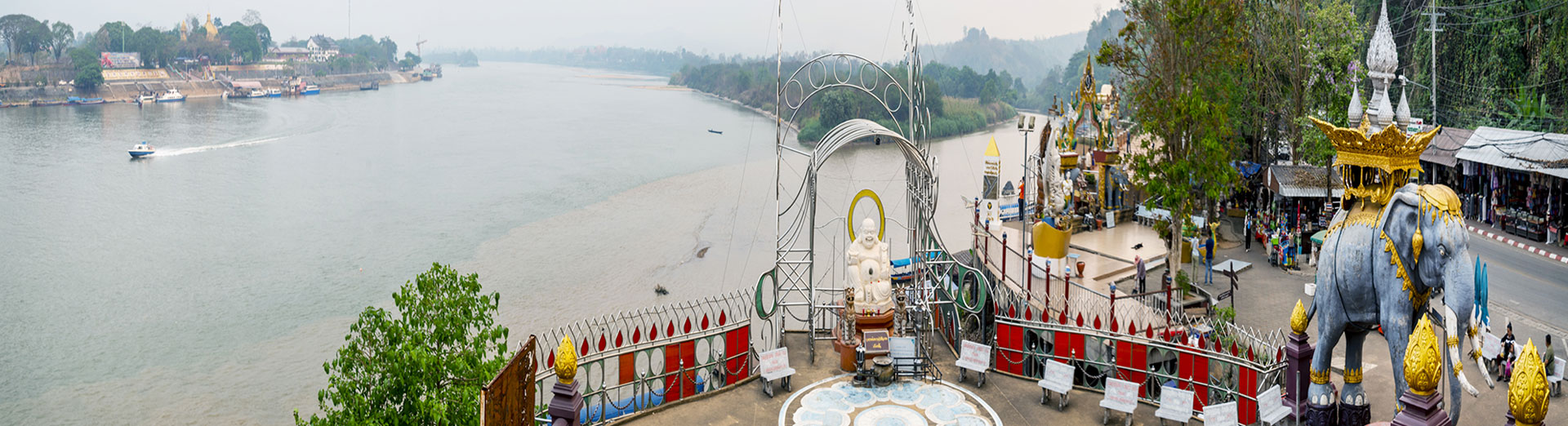 Riverside viewpoint with an elephant statue and shrine above the Mekong