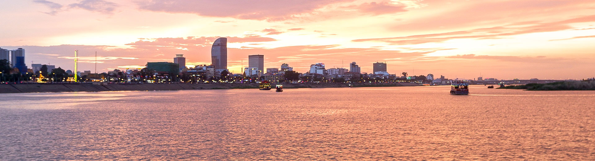 City skyline across a wide river at sunset